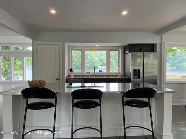 a kitchen with stainless steel appliances kitchen island a large window and cabinets
