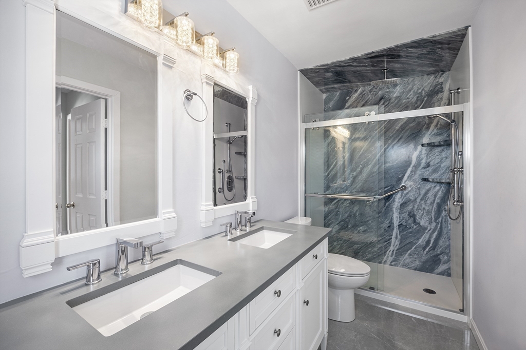 30 Commodore Court, Unit 30 Hull, MA 02045 - Photo 20 of 42 a bathroom with a double vanity sink mirror and toilet