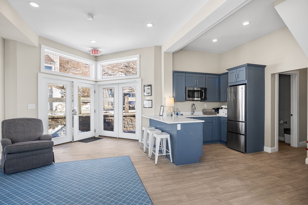 30 Commodore Court, Unit 30 Hull, MA 02045 - Photo 33 of 42 a large living room with stainless steel appliances granite countertop a couch and cabinets