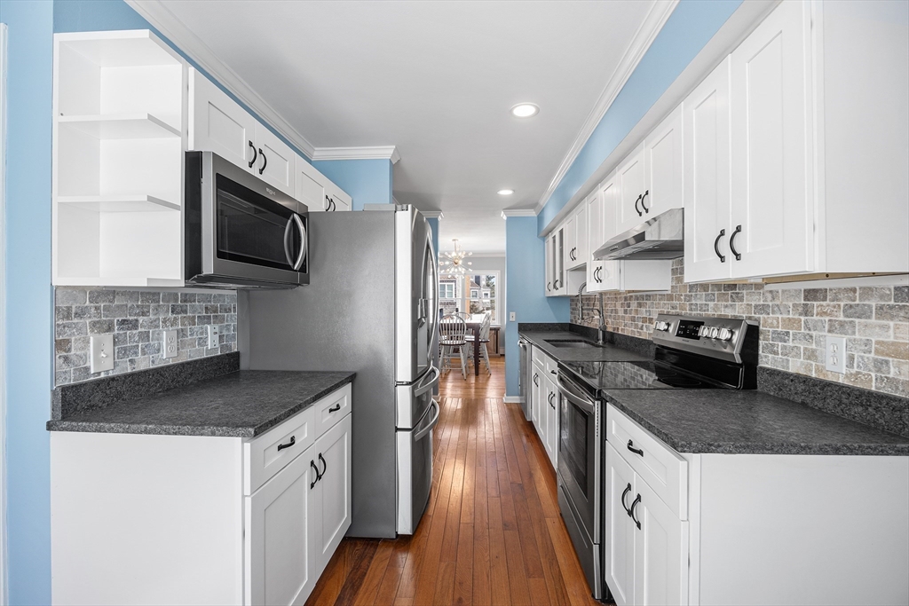 30 Commodore Court, Unit 30 Hull, MA 02045 - Photo 8 of 42 a kitchen with stainless steel appliances granite countertop a stove top oven a sink a microwave and a refrigerator
