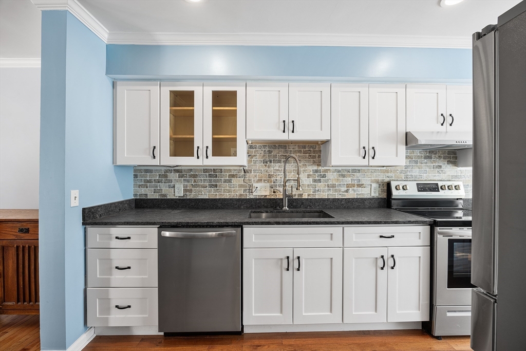 30 Commodore Court, Unit 30 Hull, MA 02045 - Photo 9 of 42 a kitchen with granite countertop a sink cabinets and stainless steel appliances