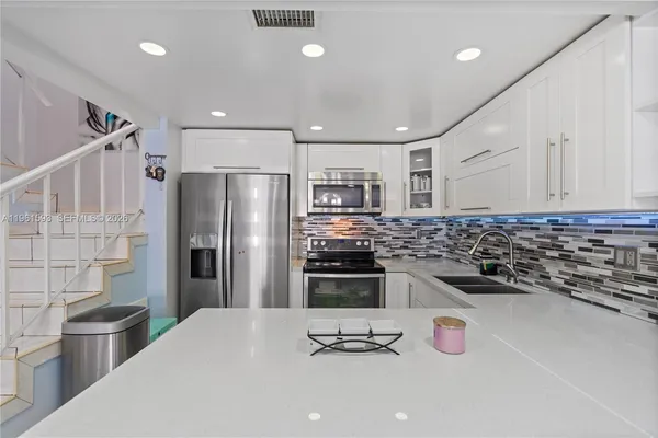 a kitchen with stainless steel appliances a refrigerator sink and stove