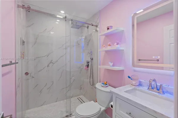 a bathroom with a sink toilet vanity and shower