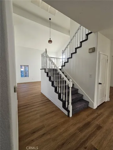 a view of staircase with wooden floor and white walls