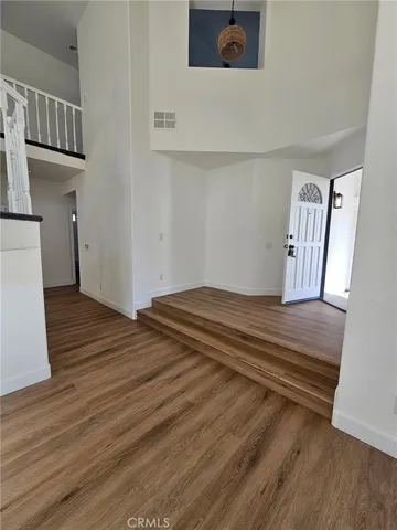 a view of a livingroom with wooden floor and stairs
