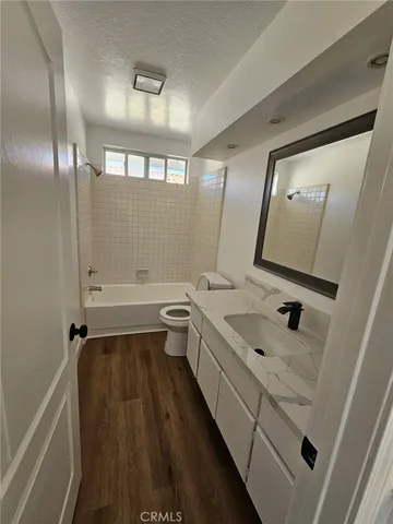 a bathroom with a double vanity sink and mirror with toilet