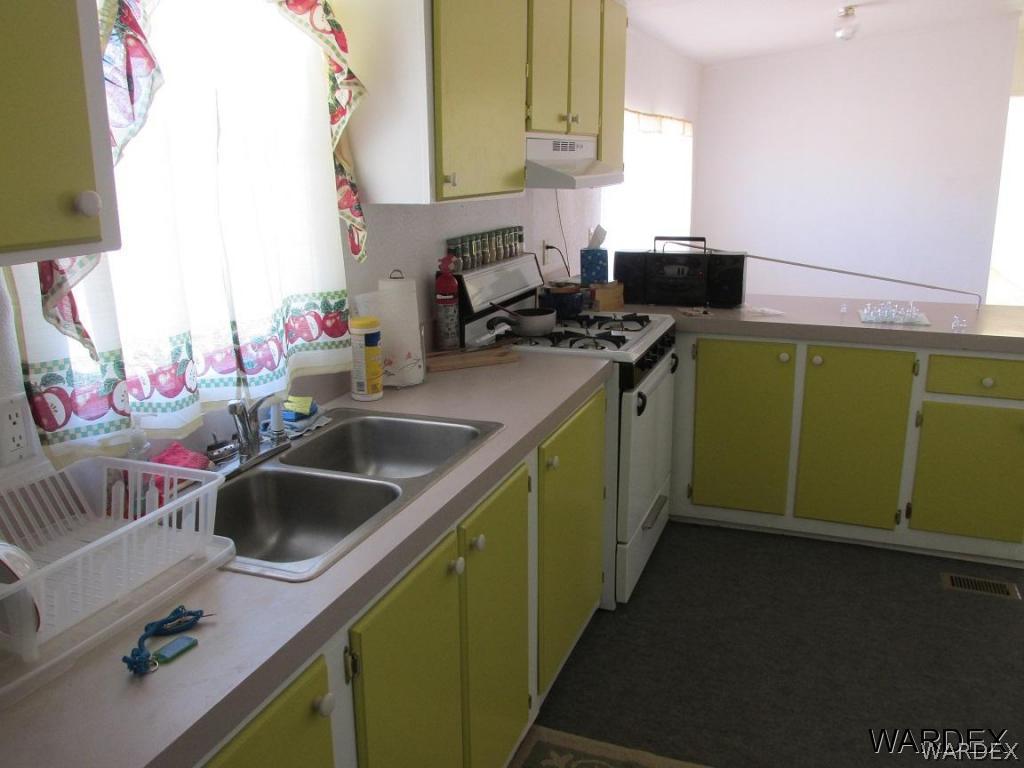 3936 Tonto Road Golden Valley, AZ 86413 - Photo 22 of 29 a kitchen with a sink and a stove next to a window