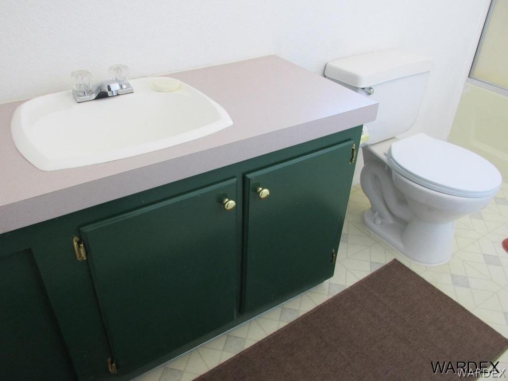 3936 Tonto Road Golden Valley, AZ 86413 - Photo 28 of 29 a bathroom with a sink a toilet and vanity