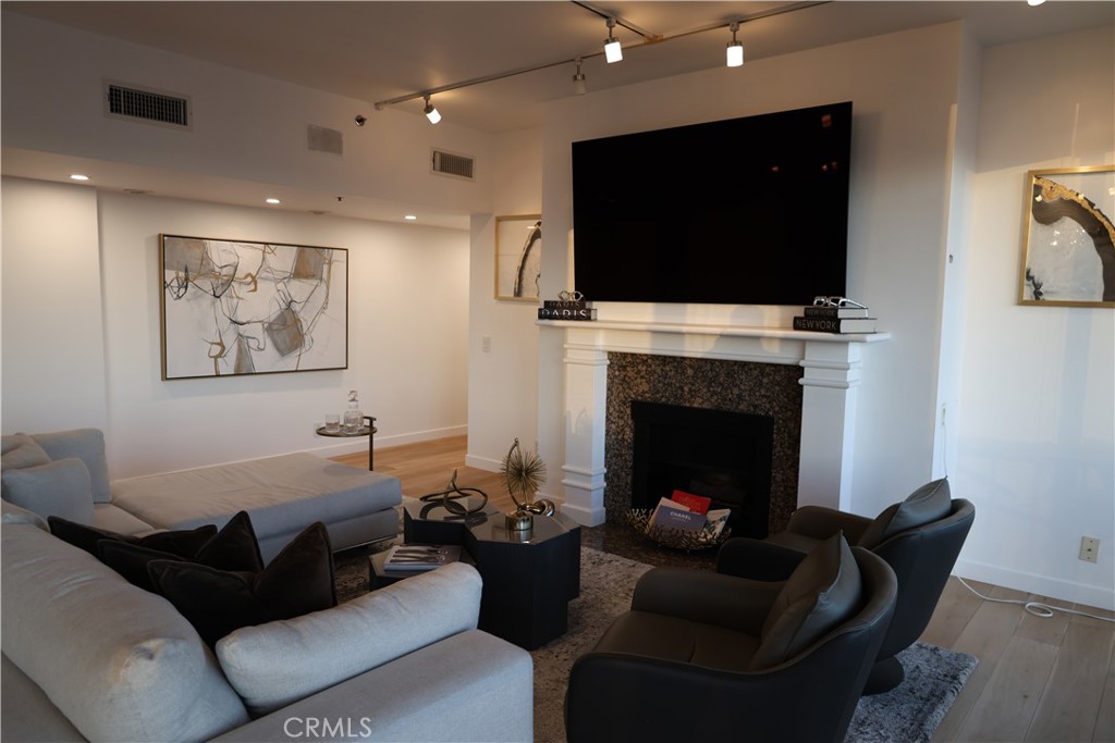 222 Monterey Road, Unit 1603 Glendale, CA 91206 - Photo 12 of 38 a living room with furniture a flat screen tv and a fireplace