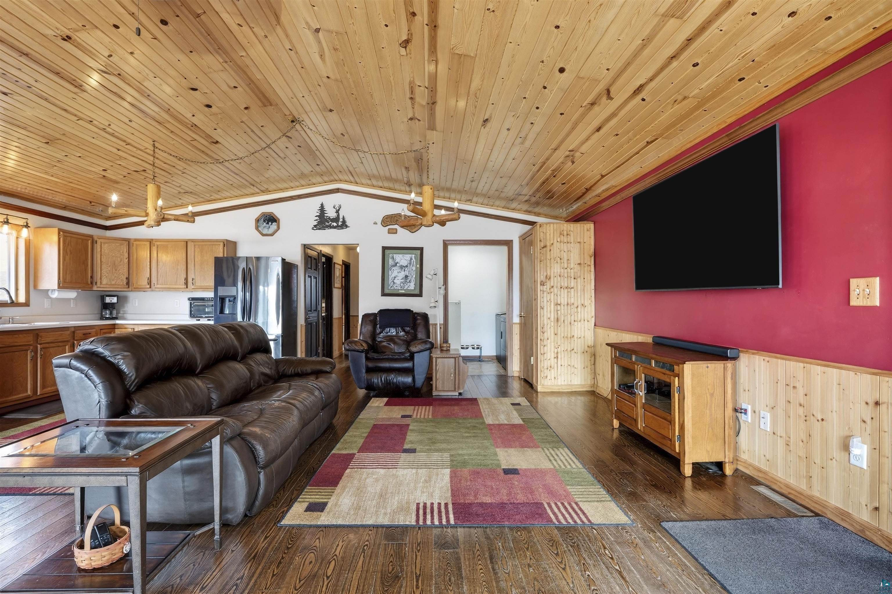 11702 East Mail Road Gordon, WI 54838 - Photo 24 of 43 Living area featuring wainscoting, wooden ceiling, and dark wood finished floors