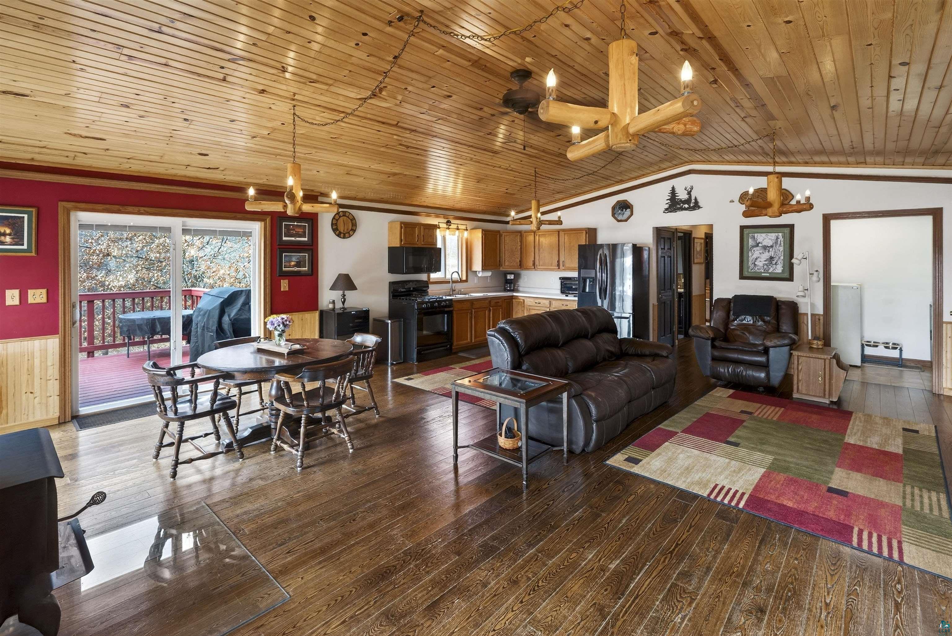 11702 East Mail Road Gordon, WI 54838 - Photo 33 of 43 Living room with wood ceiling, dark wood finished floors, a wainscoted wall, and a chandelier