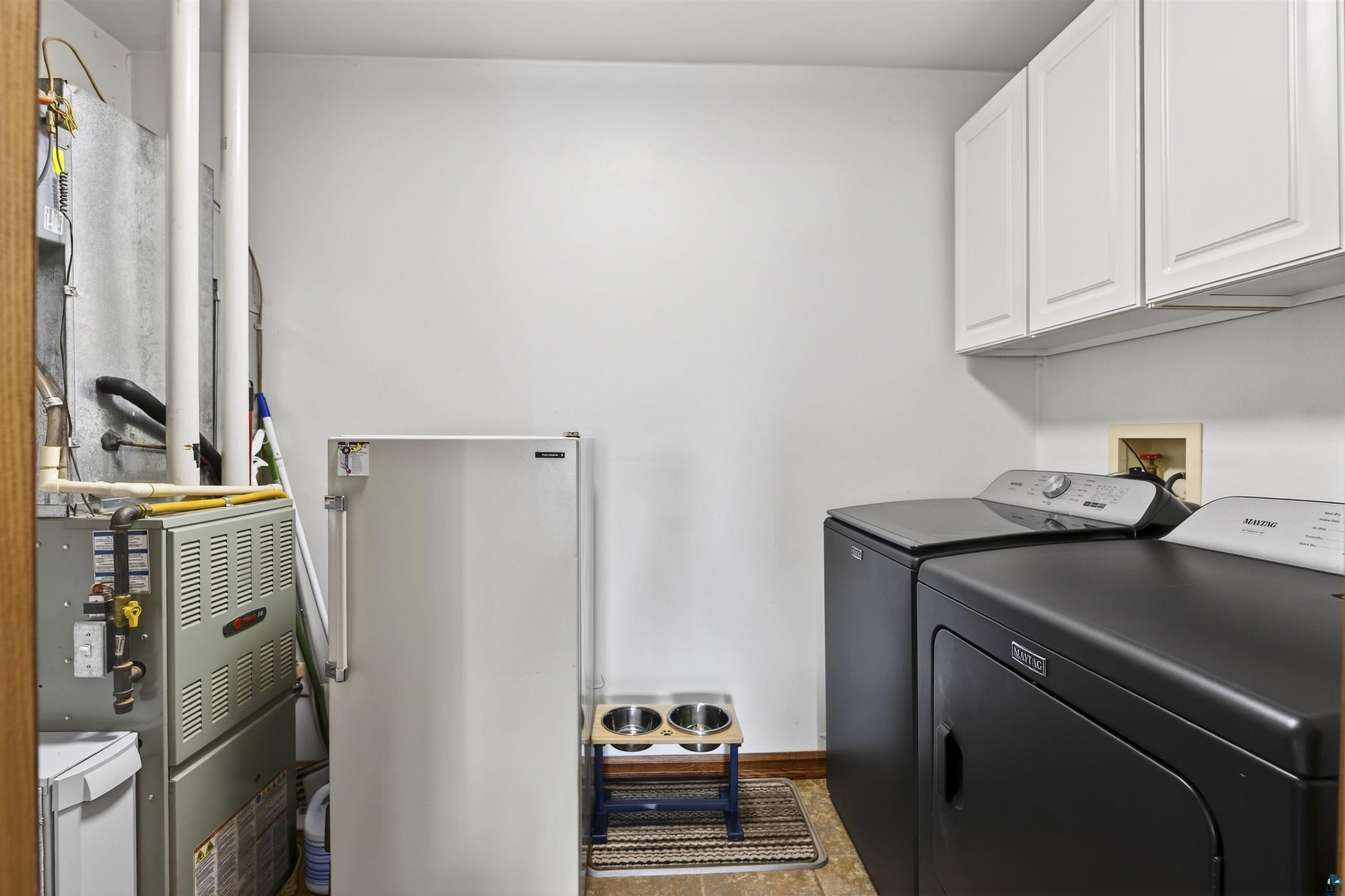 11702 East Mail Road Gordon, WI 54838 - Photo 39 of 43 Laundry room featuring heating unit, washing machine and dryer, and cabinet space