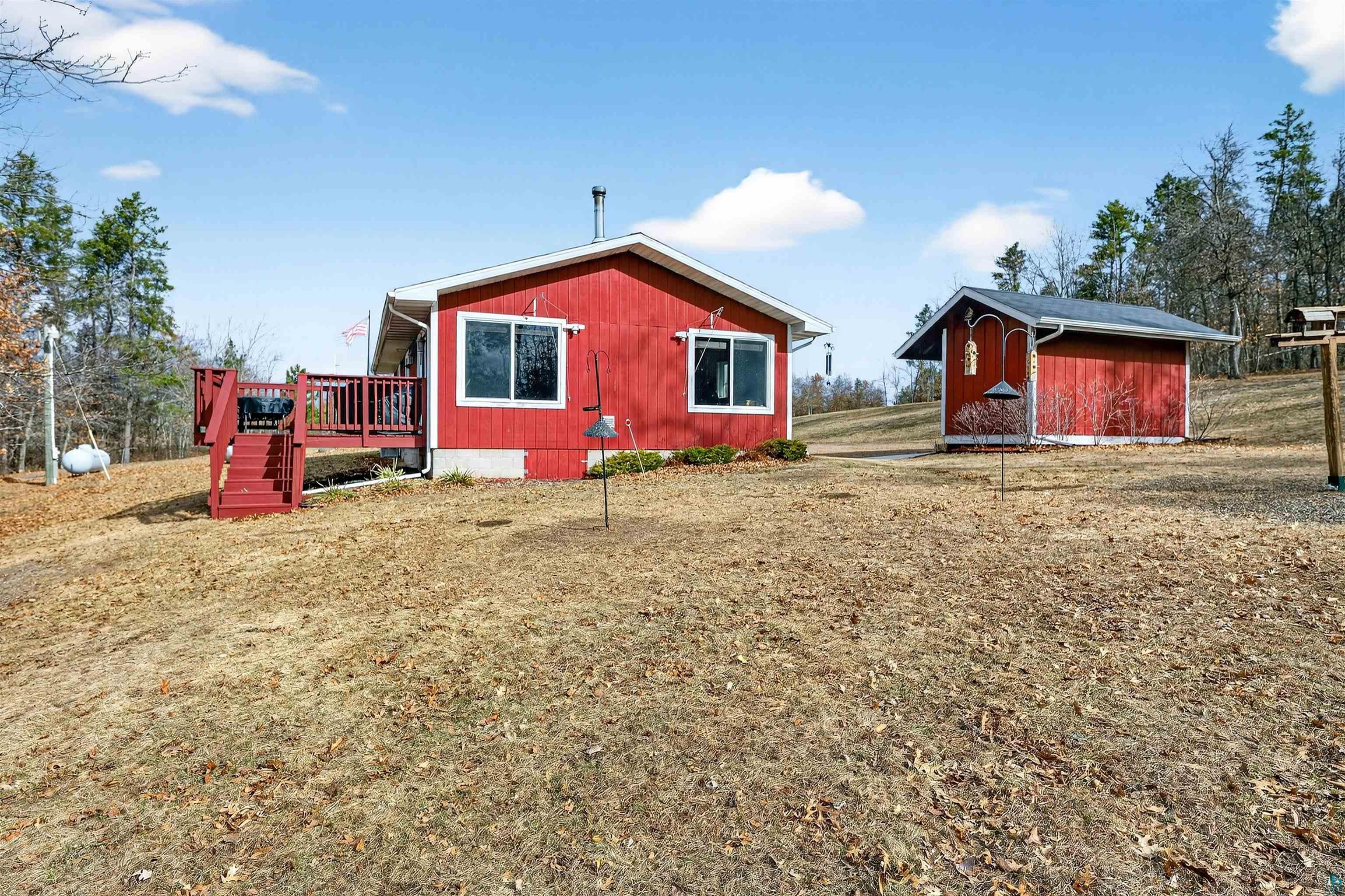 11702 East Mail Road Gordon, WI 54838 - Photo 8 of 43 View of side of property with a wooden deck, a storage unit, and a lawn
