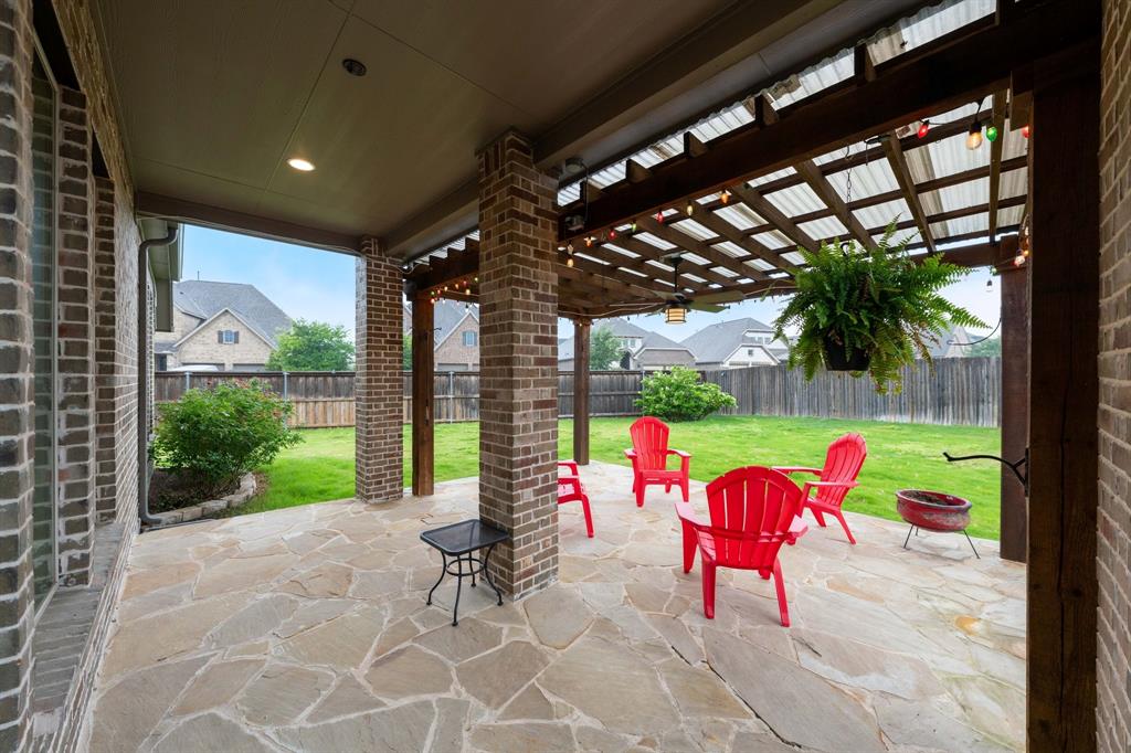 1501 Calcot Lane Forney, TX 75126 - Photo 26 of 34 Expansive outdoor patio featuring flagstone flooring and a wood pergola with a translucent roof