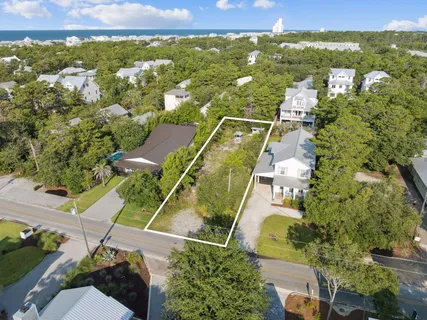 an aerial view of residential houses with outdoor space and ocean view