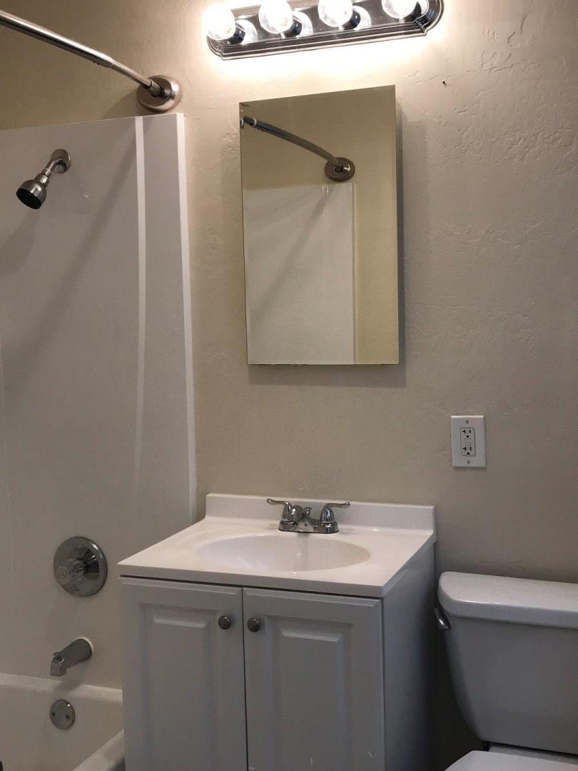 445 Esplanade Avenue, Unit 2 Pacifica, CA 94044 - Photo 8 of 10 a bathroom with a sink and mirror with toilet