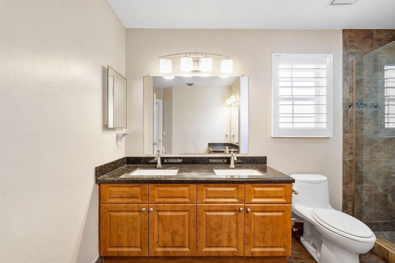 17270 Boca Club Boulevard, Unit 1707 Boca Raton, FL 33487 - Photo 24 of 68 a bathroom with a granite countertop sink a toilet and mirror