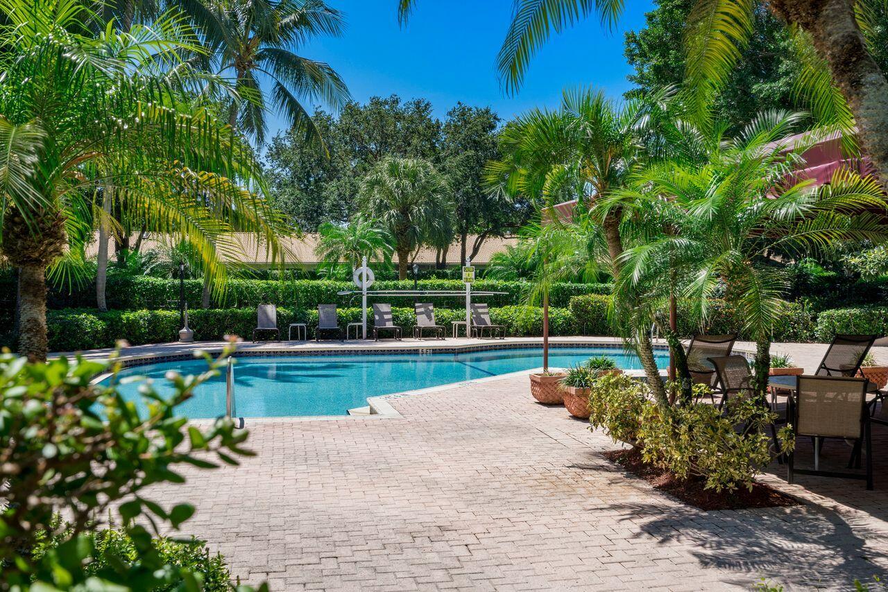 17270 Boca Club Boulevard, Unit 1707 Boca Raton, FL 33487 - Photo 56 of 68 a view of a swimming pool with a patio and a garden