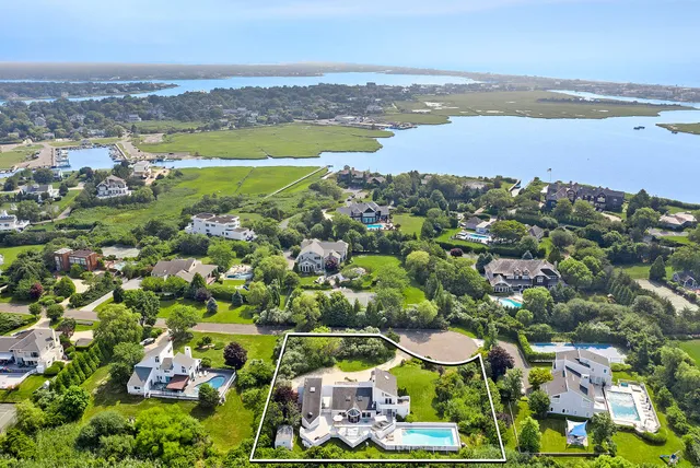 an aerial view of residential houses with outdoor space and swimming pool