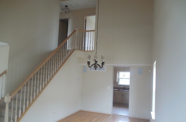 152 Sedgewicke Drive Romeoville, IL 60446 - Photo 4 of 16 a view of a hallway with wooden floor and stairs