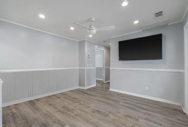 an empty room with wooden floor and windows