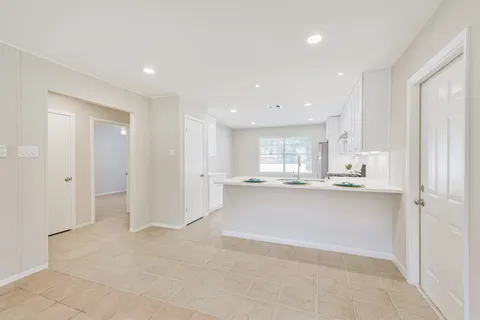 a view of kitchen with kitchen island sink refrigerator and cabinets
