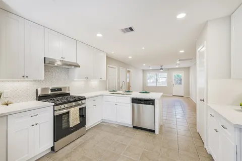 a kitchen with stainless steel appliances granite countertop a sink and cabinets
