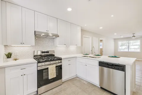a kitchen with granite countertop white cabinets and white appliances