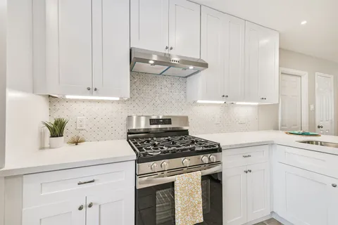 a kitchen with stainless steel appliances granite countertop a sink a stove and cabinets