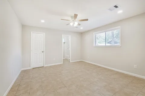 an empty room with fan and windows