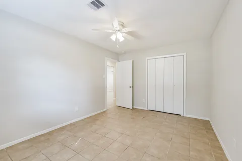 an empty room with a ceiling fan and a window