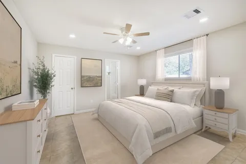 a bedroom with a large bed and a chandelier