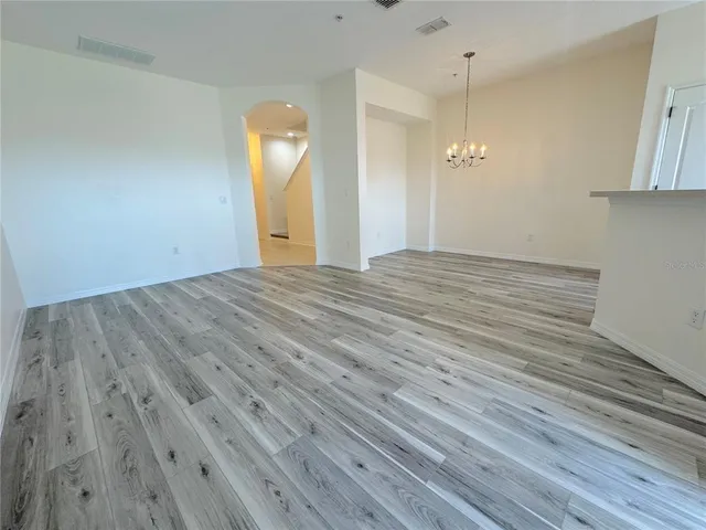 a view of a room with wooden floor and entryway