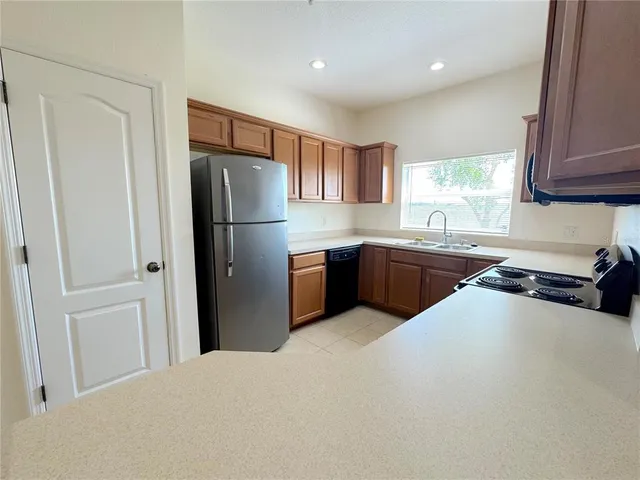 a kitchen with stainless steel appliances a refrigerator a sink a stove a microwave and island