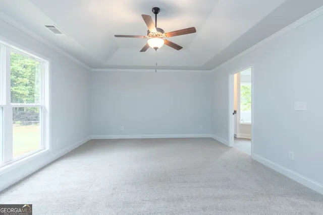 an empty room with a window and a ceiling fan