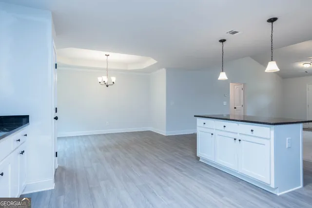 a view of a kitchen with wooden floor and a sink