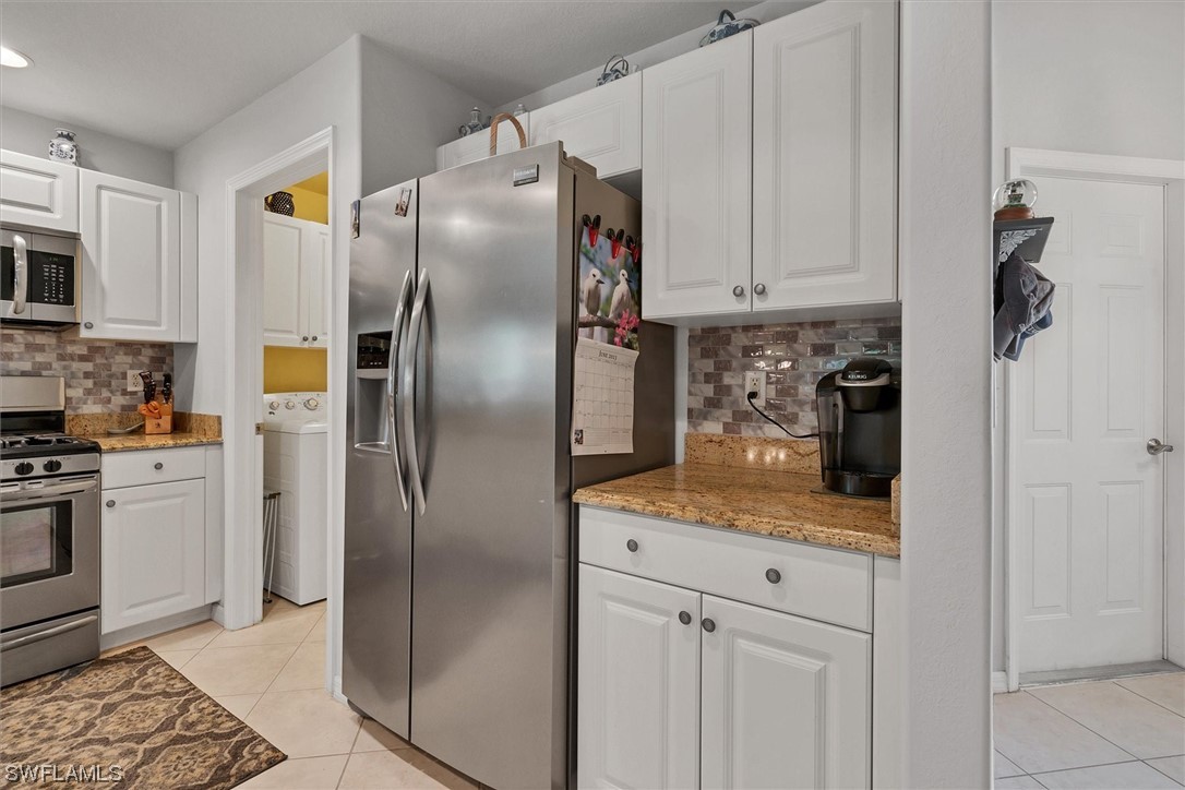 19654 Villa Rosa Loop Estero, FL 33967 - Photo 8 of 37 a kitchen with stainless steel appliances granite countertop a refrigerator a stove and a sink with cabinets