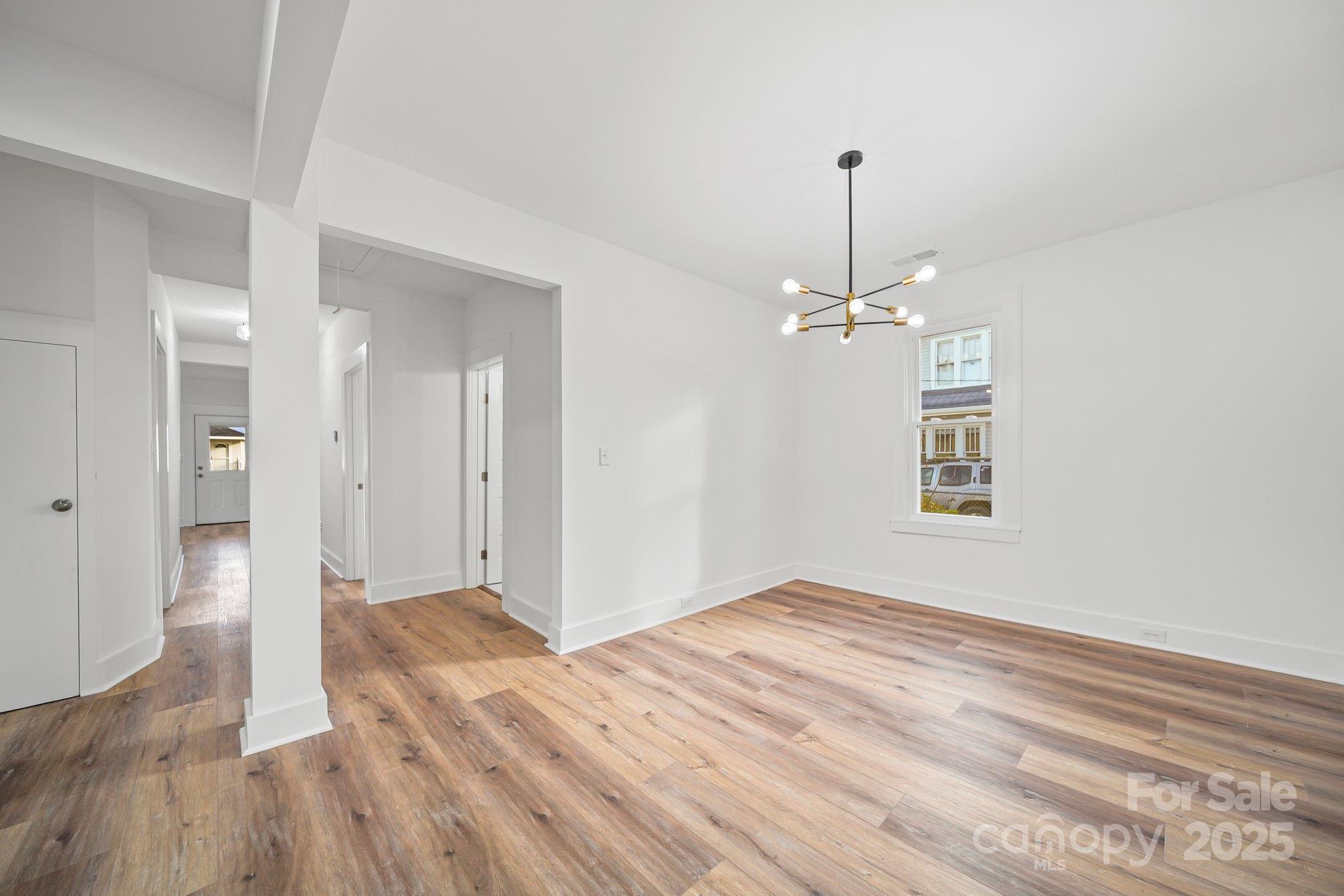1703 Lowder Street Albemarle, NC 28001 - Photo 12 of 31 a view of a room with wooden floor chandelier and window