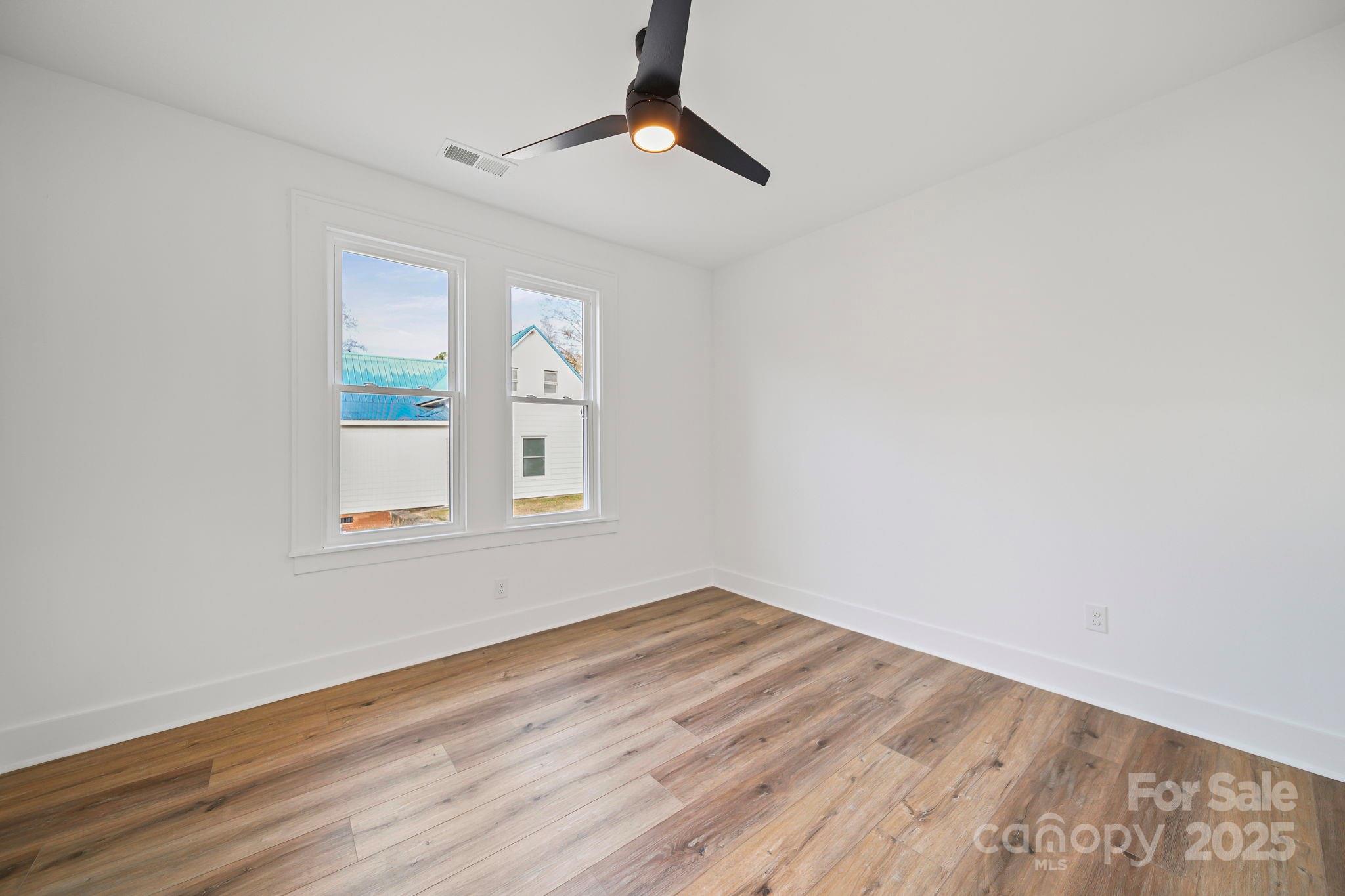 1703 Lowder Street Albemarle, NC 28001 - Photo 17 of 31 a view of empty room with wooden floor and fan