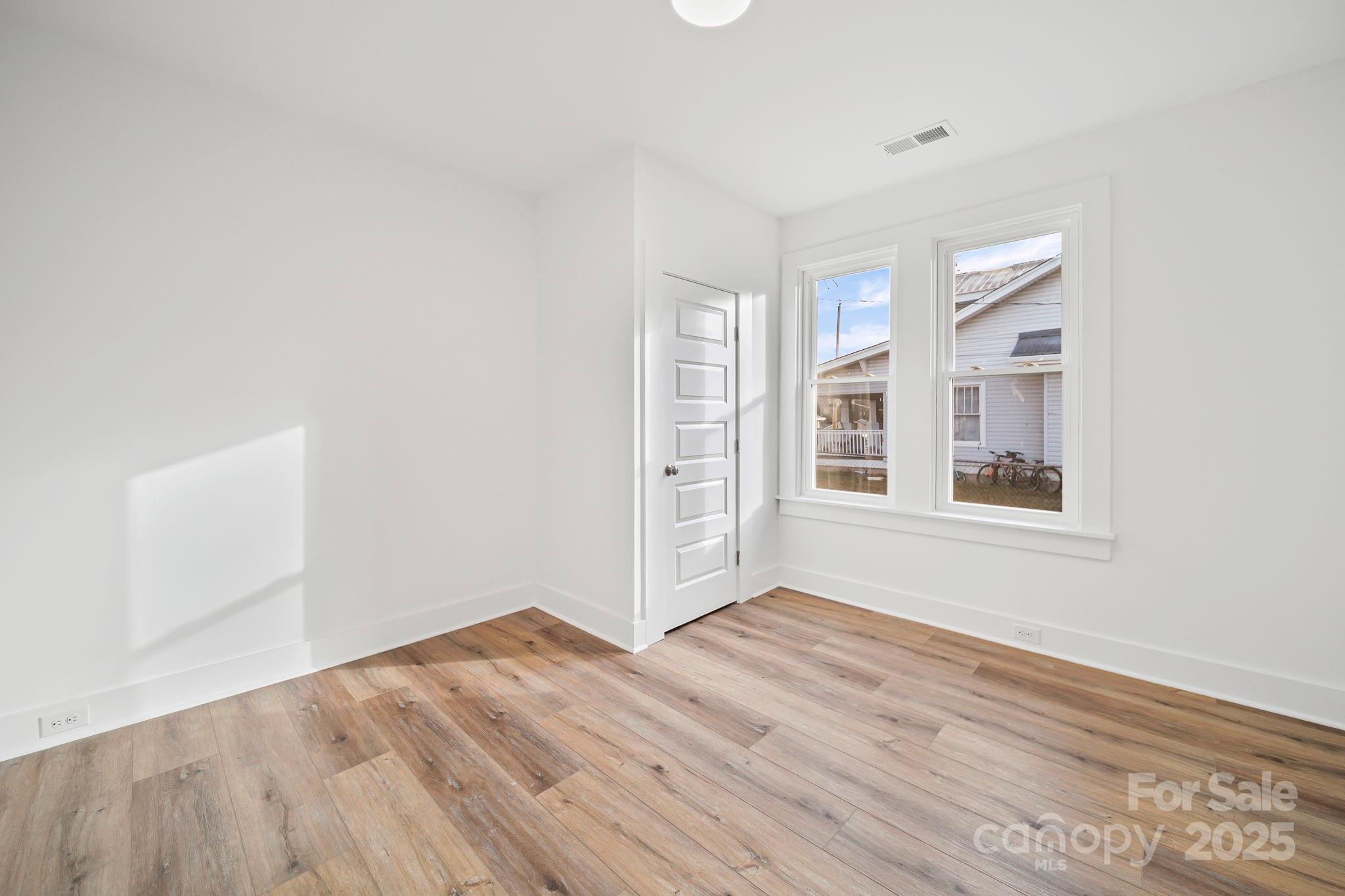1703 Lowder Street Albemarle, NC 28001 - Photo 24 of 31 a view of an empty room with wooden floor and a window