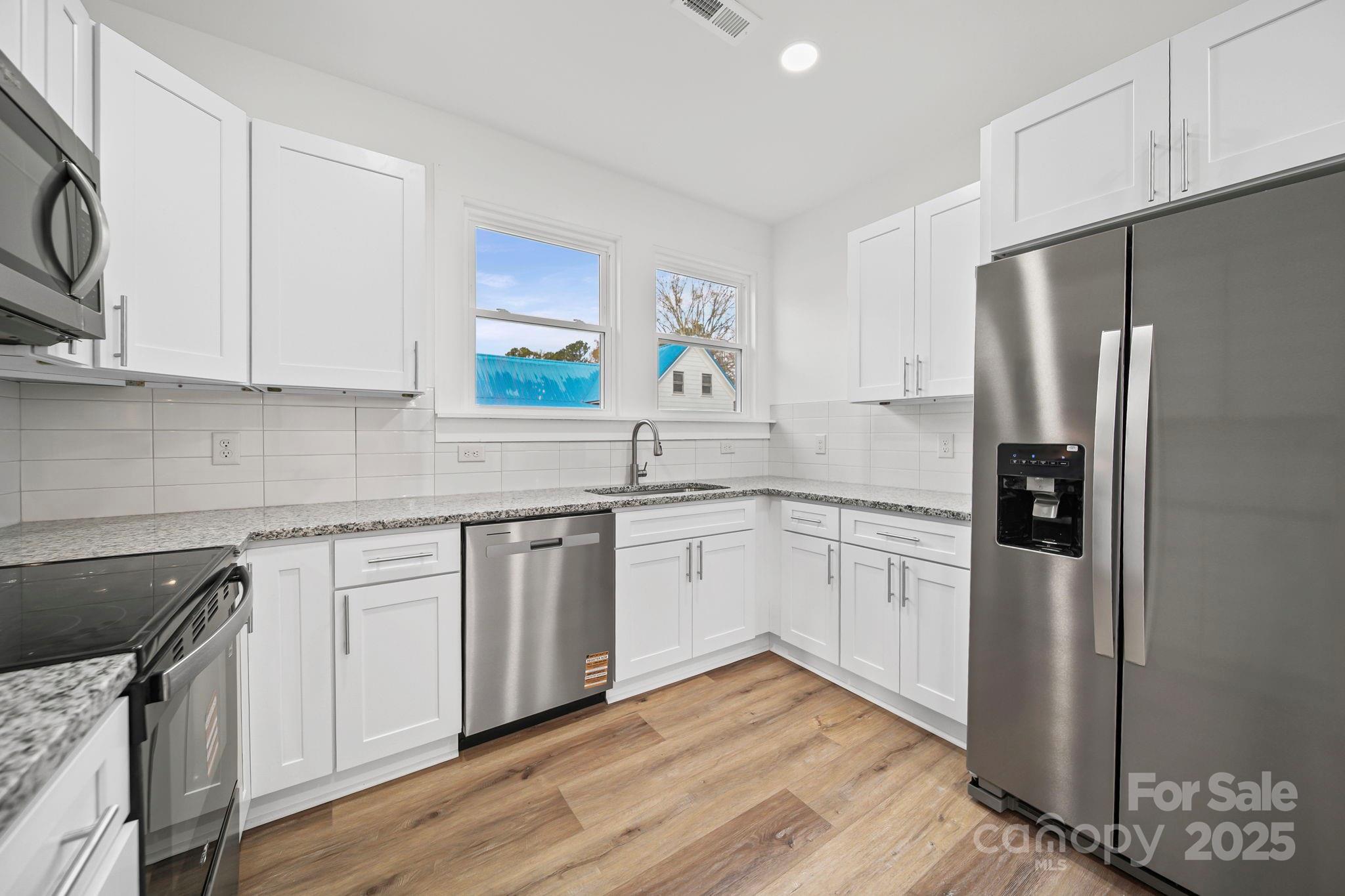 1703 Lowder Street Albemarle, NC 28001 - Photo 5 of 31 a kitchen with a refrigerator sink and cabinets