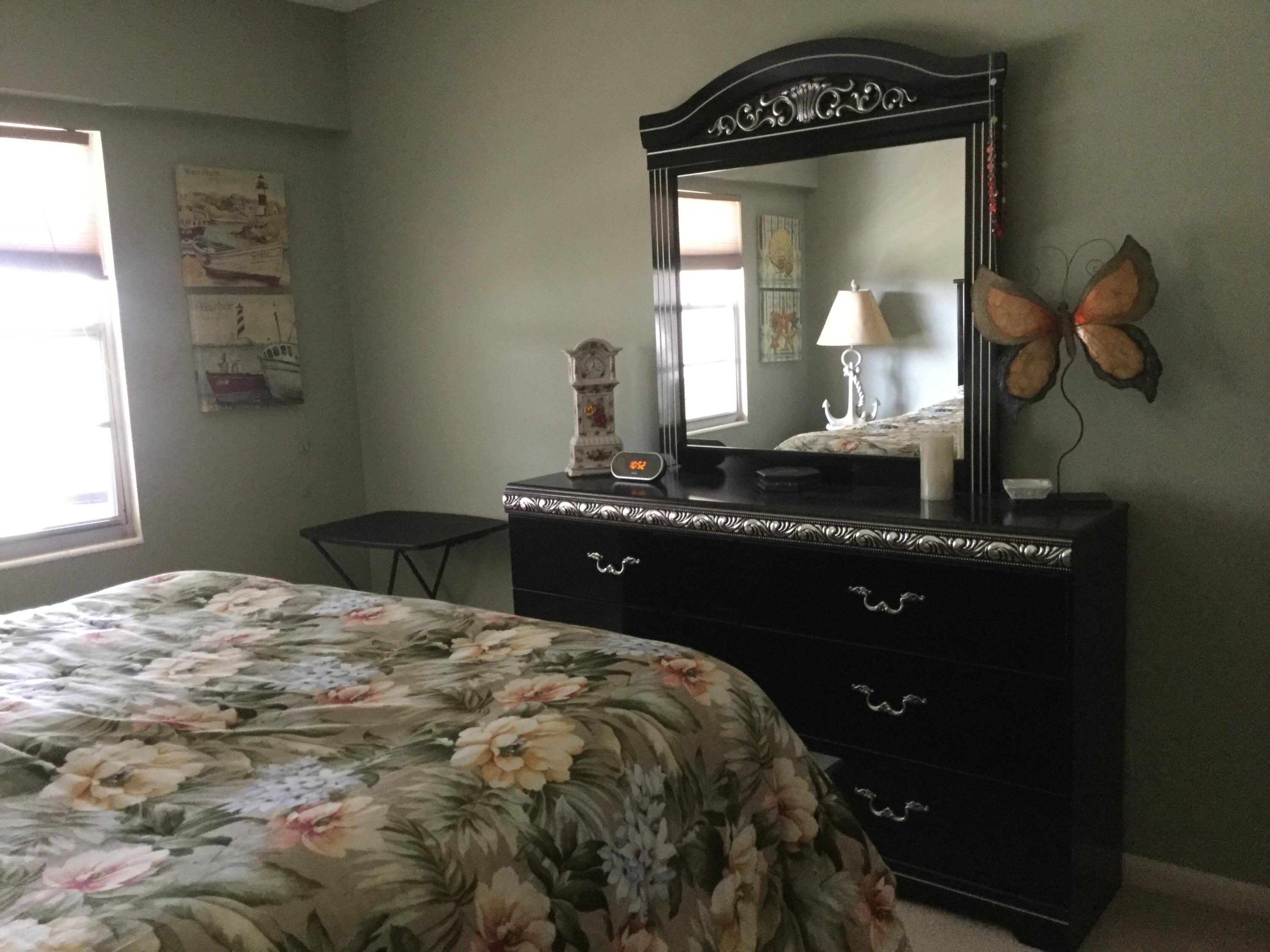 124 Dorset C, Unit 124C Boca Raton, FL 33434 - Photo 19 of 21 a bedroom with a bed and a mirror