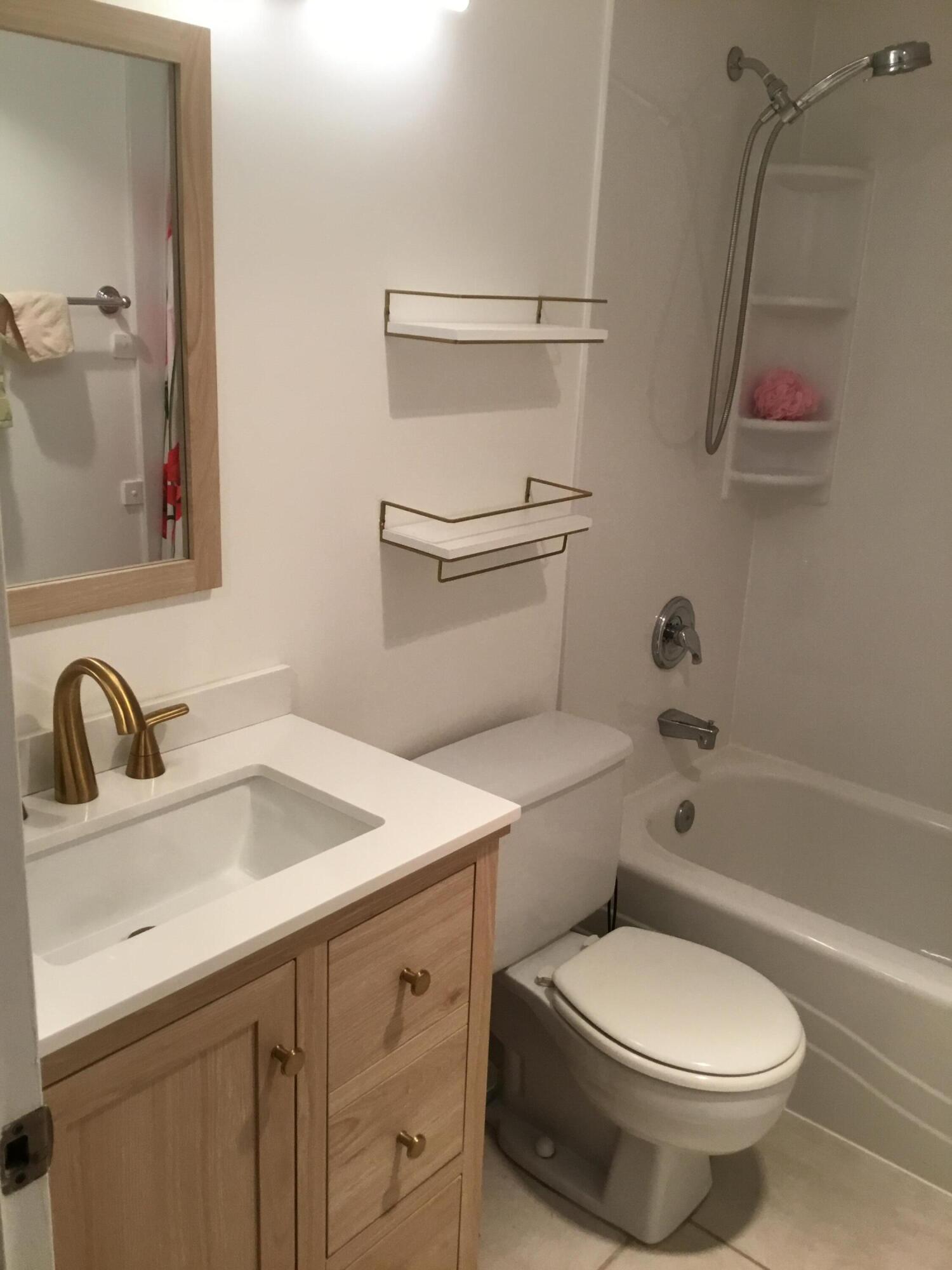 124 Dorset C, Unit 124C Boca Raton, FL 33434 - Photo 8 of 21 a bathroom with a sink toilet and shower