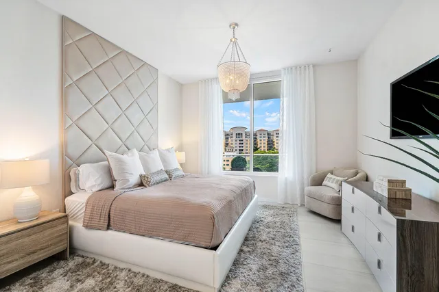 a spacious bedroom with a bed and a flat screen tv