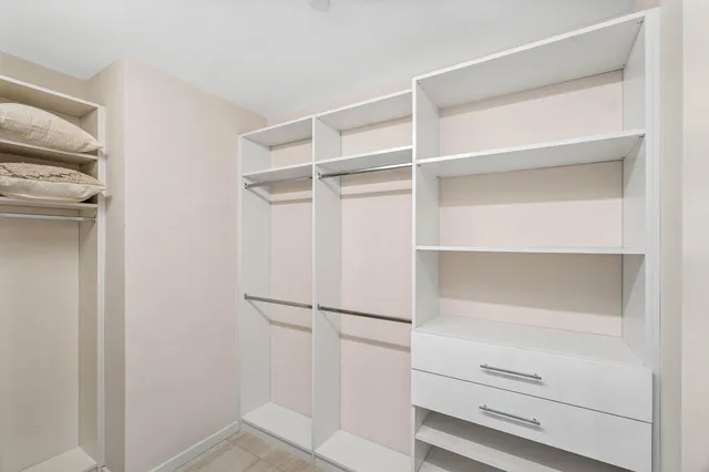 a view of walk in closet with empty racks