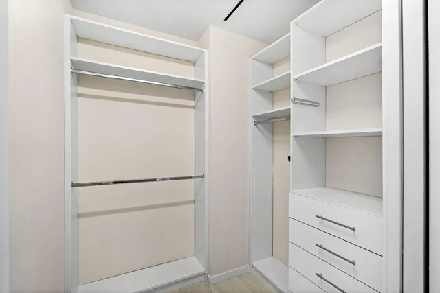 a view of walk in closet with empty racks