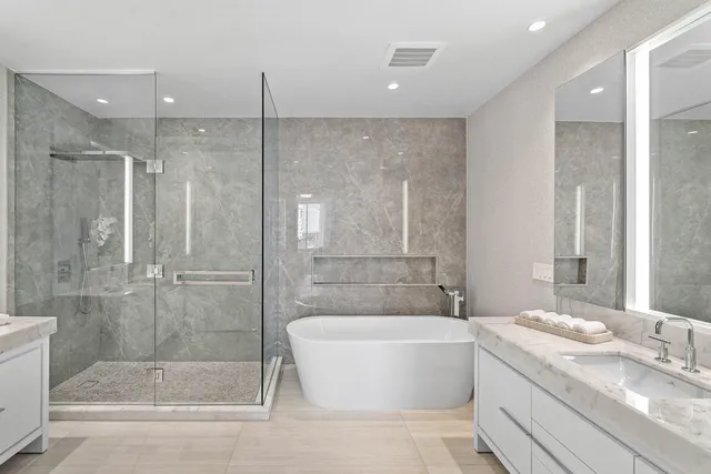 a bathroom with a granite countertop bathtub shower and sink
