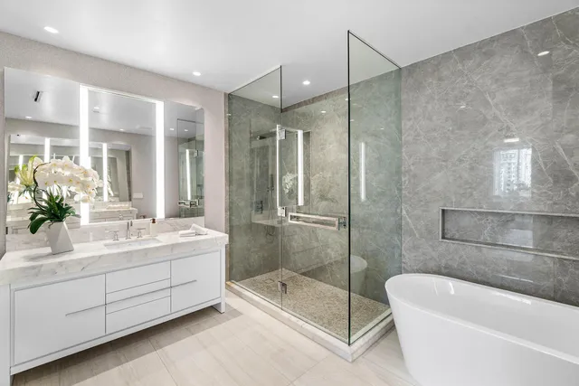 a bathroom with a bathtub shower sink and mirror