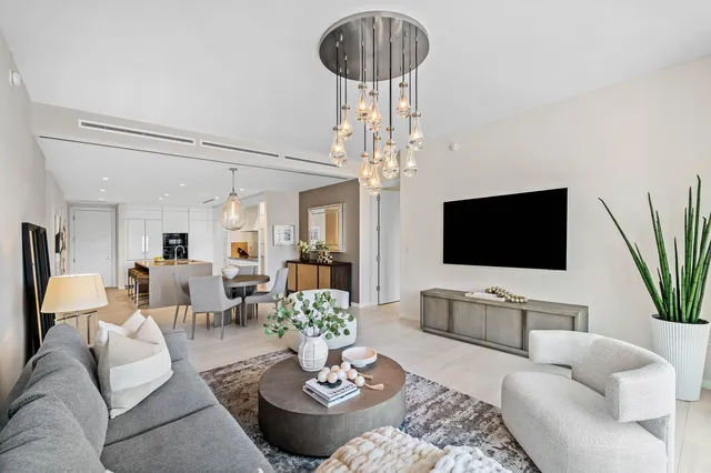 a living room with furniture a chandelier and a flat screen tv