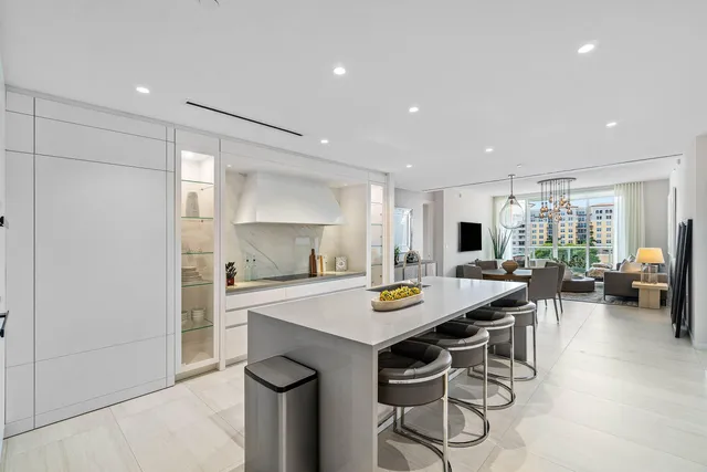 a open dining room with stainless steel appliances a table and chairs